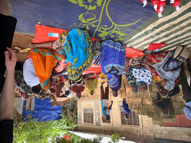 En gruppe mennesker i Zanzibar som sitter på bakken