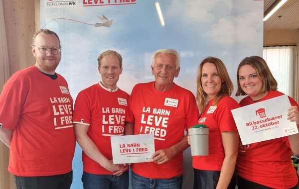 Fem ansatte fra TV-aksjonen og Strex står i TV-aksjons tskjorter og holder plakater og bøsse.