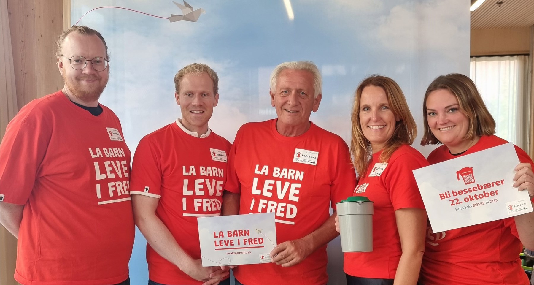Fem ansatte fra TV-aksjonen og Strex står i TV-aksjons tskjorter og holder plakater og bøsse.