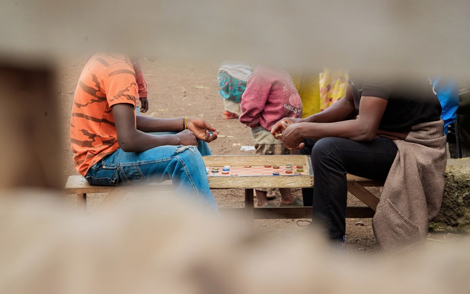 Kantene på bildet er blurry. I midten av bildet ser vi deler av to personer som spiller et brettspill.