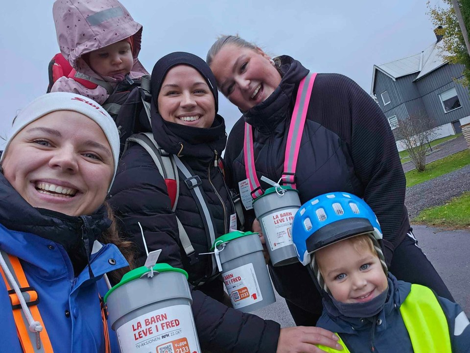 Tre voksne damer og to barn har på refleks og høstklær ute og står med bøsser. 