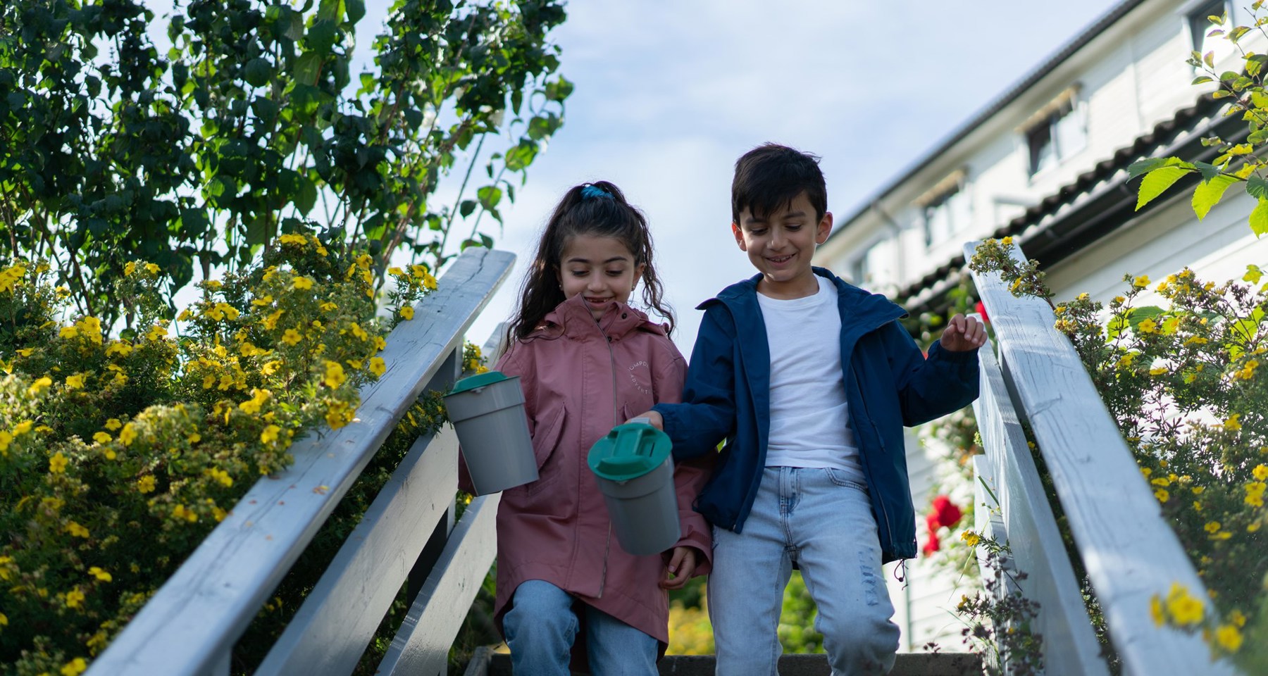 To barn går ned en trapp, og holder hver sin bøsse i hendene 