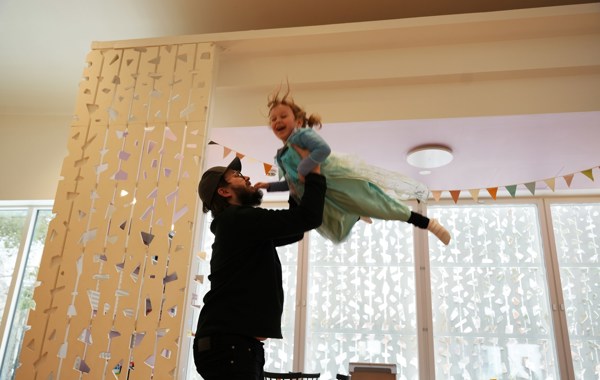 Far leker med datter i prinsessekjole, som kastes opp i lufta